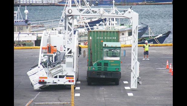 A container trailer truck goes through the M60 container scanner equipment around 7a.m. on Monday, Apr. 3, when the scanner operation as well as the scanner fee, went into effect, at the main dock of the Port of Pago Pago. Customs officials says some 30-plus containers were scanned on Monday. [photo: Fili Sagapolutele]