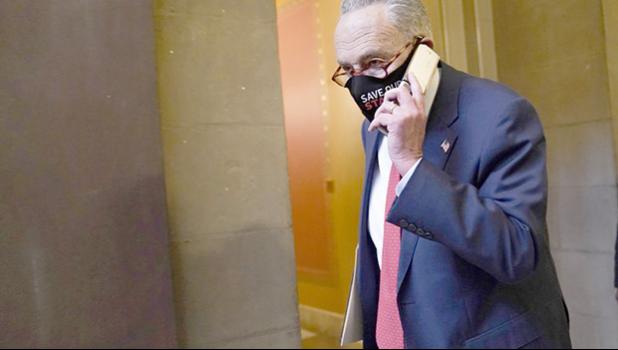 Senate Minority Leader Sen. Chuck Schumer of N.Y., walks on Capitol Hill in Washington, Tuesday, Dec. 15, 2020. (AP Photo/Susan Walsh) Sen. Chuck Schumer