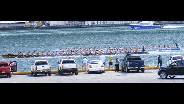 A look at the competition between Fuao from Vatia and Paepaeulupo’o of Aua as they pass in front of the main dock of Pago Pago Harbor, heading towards the finish line. Fauo i is the one closer to the dock side.  [photo: Fili Sagapolutele]