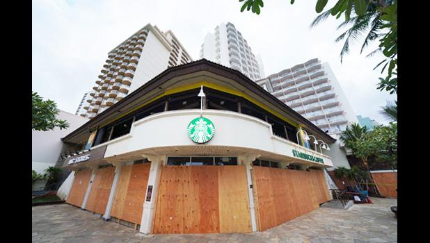 A Waikiki Starbucks coffee shop near Kapahulu Avenue with windows boarded up