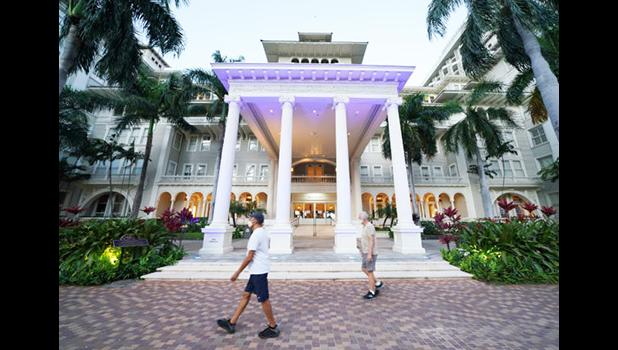Many fewer people are walking the streets of Waikiki during the COVID-19 pandemic. These people were maintaining social distancing on Thursday in front of the Moana Surfrider Hotel. [photo: Cory Lum/Civil Beat[ People maintaining social distancing on Thursday in front of the Moana Surfrider Hotel in Waikiki