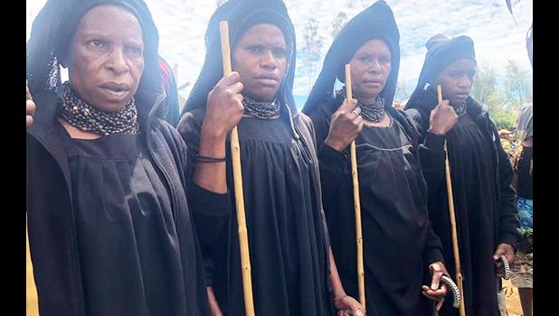 Highlands women dressed in long black robes attending a funeral 