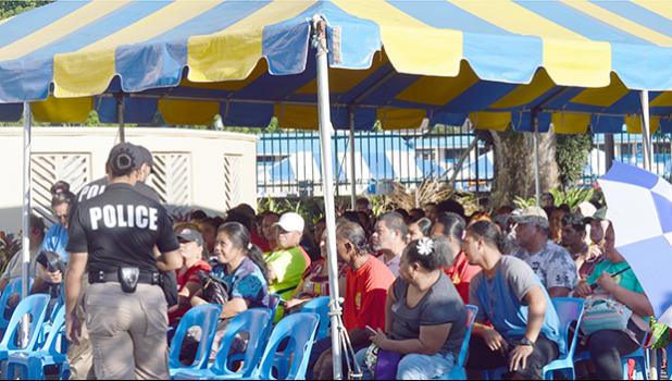 Crowds of people under tent waiting to cash stimulus checks