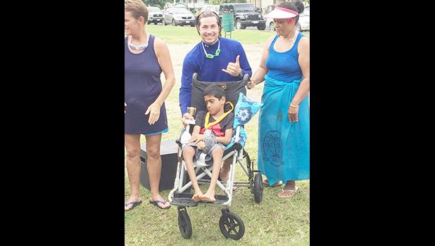 Athlete Miracle Singh, a 10-year-old from Leone poses with a volunteer, Earl, and his family after receiving a trophy and silver medal during the awards ceremony after the adaptive aquatic Swim Meet held last Saturday in Utulei.  [Photo: Ese Malala]