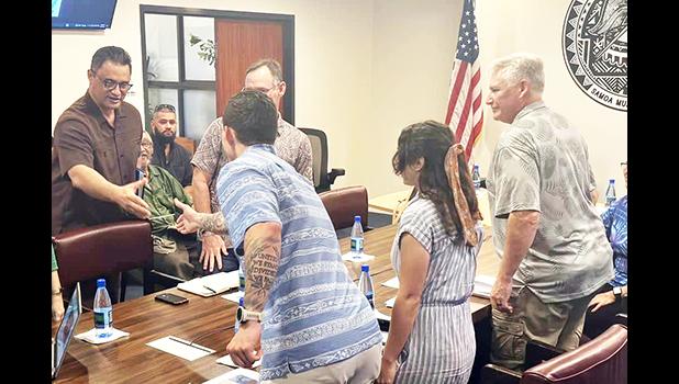 Talauega shakes hands with Army Corps officials