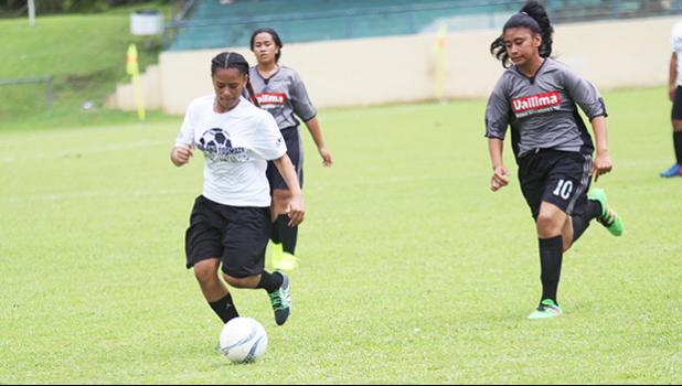 An Ilaoa & To’omata player dribbles away from a Taputimu Youth defender 