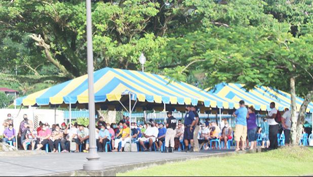 Crowds of people waiting under tents at TBAS to cash their stimulus checks