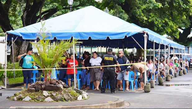 Large crowd under tents in the parking lot of the Territorial Bank of American Samoa