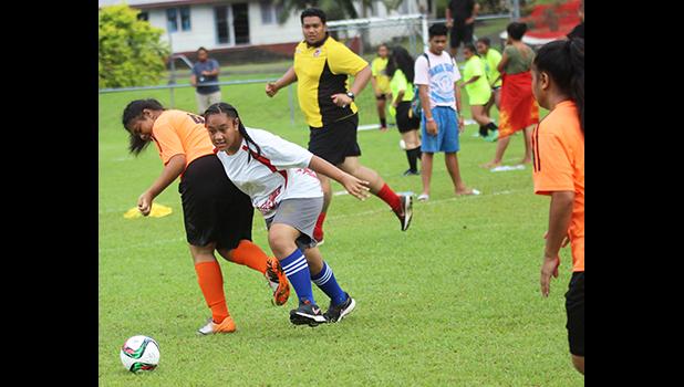 A Vaiala Tongan player dribbles by an Utulei Youth defender 