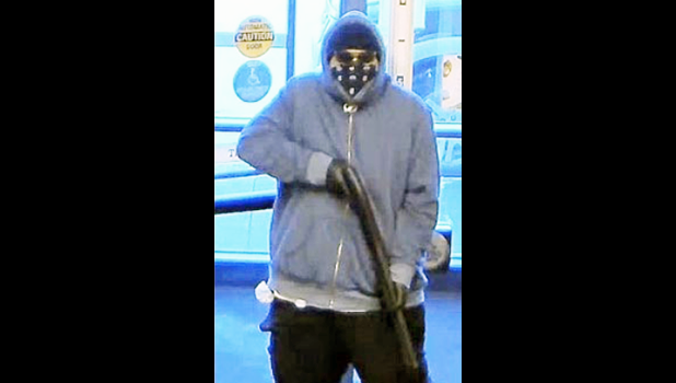 Totoe Opeti Sakaria, Jr., who is masked, wearing sunglasses and holding a shotgun