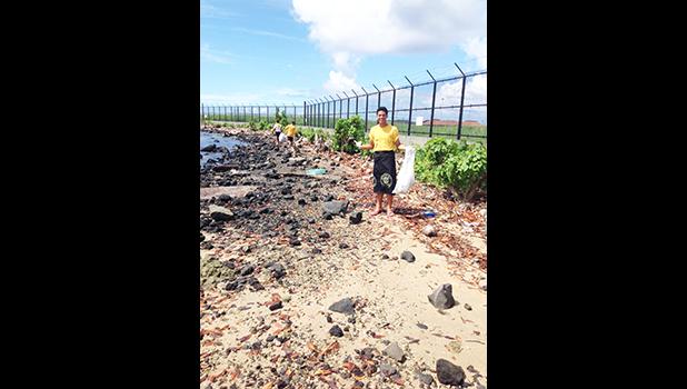 A Nu’uuli Vocational Technical High School (NVTHS) science student, and two others in the background, participating in the “Vo-Tech Gets Involved” trash collection project, along Lion’s Park shoreline. NVTHS science teacher, Adelle Posala Talaeai spearheads the project, and was awarded a Teacher's Challenge Award from the Coral Reef Advisory Group (CRAG) for its inception. [photo: NVTHS]