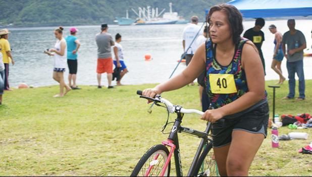 Zeniah — a 19-year-old female from Pago Pago, who placed 2nd in the Sprint Category for her age group hurries with her bike during the triathlon that was held last week Saturday at the Utulei Beach. [photo: Ese Malala]