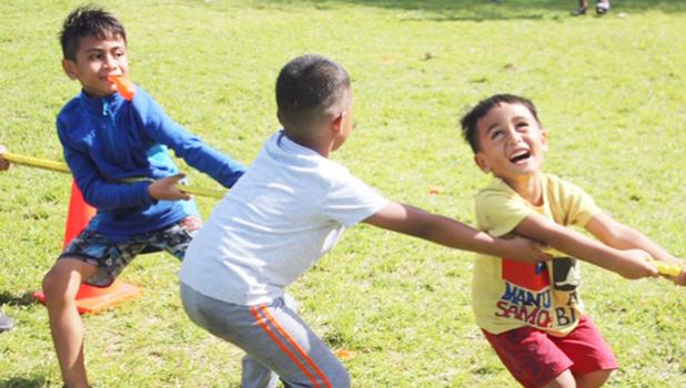 Three youngsters really enjoying themselves during the tug-of-war