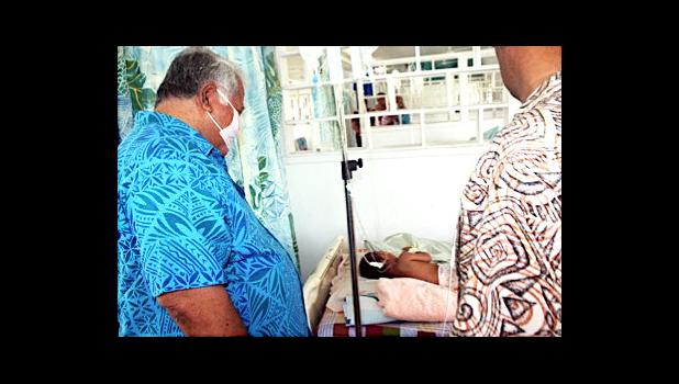 Prime Minister Tuilaepa Sailele Malielegaoi in a mask with sick child