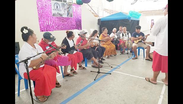 Senior citizens, students and others playing ukulele