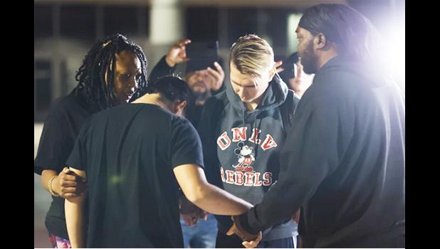 University of Nevada, Las Vegas, student Carlos Casillas, 23, second from right, prays at the Las Vegas Convention Center reunification area where he was transported after a fatal shooting at the campus in Las Vegas, Wednesday, Dec. 6, 2023. (Wade Vandervort/Las Vegas Sun via AP) University of Nevada, Las Vegas, student