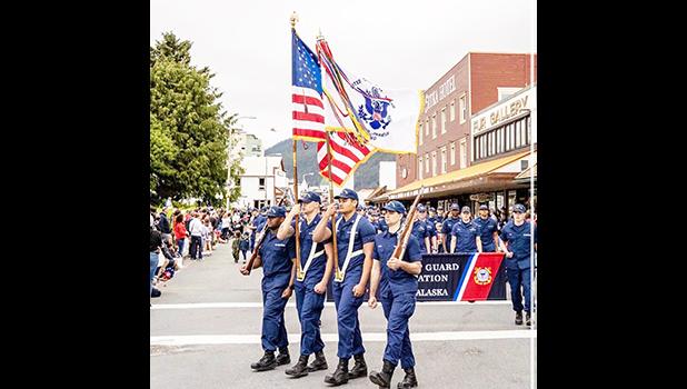 Leonrhee K. Alaimaleata carrying USCG flag in formation