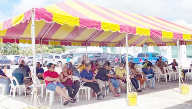 A crowd under a tent waiting to get vaccinated