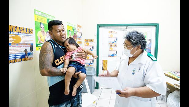 MAN WITH CHILD GETTING A VACCINATION