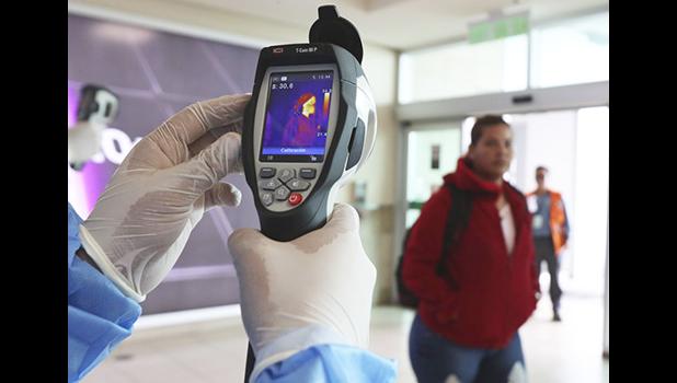 A Health Ministry staffer monitors the body temperature of travelers deplaning from international flights at the Mariscal Sucre Airport, in Quito, Ecuador, Saturday, Feb. 29, 2020. Officials in Ecuador on Saturday confirmed the first case of the new coronavirus in the South American nation. (AP Photo/Dolores Ochoa) A Health Ministry staffer monitors the body temperature of travelers n Quito, Ecuador