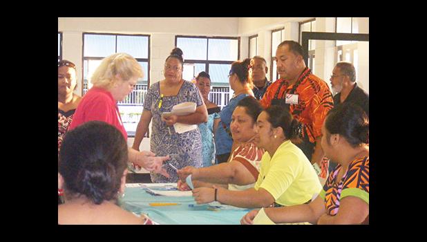 A registered voter (left) speaking to election officials seconds after the polling station at Ili’ili opened at 6a.m. today.  [photo: Fili Sagapolutele]
