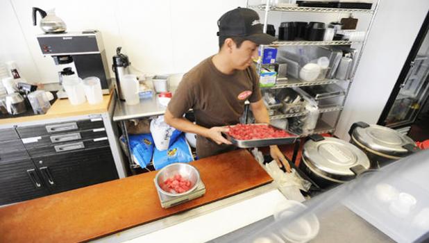 Saul De La Rosa prepares a tray of poke at Aloha Poke Shop in downtown Honolulu