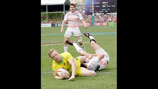 At the HSBC World Rugby Sevens Series XVIII in Hong Kong on April 8, 2017 Australia's Henry Hutchinson touches down against England to score Australia's first try.  Argentina beat England 12-10 to win Pool A.  Australia will play Argentina in the Cup quarter final.  England will play against USA.