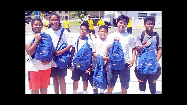 Meet the junior division champions of the first annual Manumalo Church Basketball Fellowship League: the white team, led by player coach Fitzgerald Alofa (3rd from right). The players received backpacks and school supplies provided by Papalii Laulii Alofa, who was also the head coach for the white team. See story for full details. [Courtesy photo]