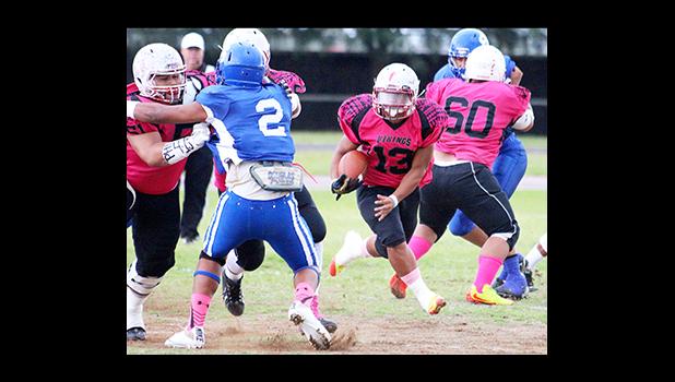 Faga’itua Vikings Leroy Fesili carrying this counter hand off towards the middle of the Sharks defense, steadily following two of his blockers double teaming Vimoto Mageo – in the opening quarter of their Varsity game last Friday evening. Samoana defeated the Vikings 24 - 22. [photo: TG]