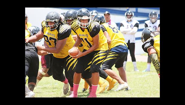 Daniel Fano of Nu’uuli, looking to send one of his backers on a running play, in the opening half of their Varsity match against the Warriors.  [photo: TG]