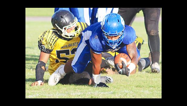 Moe Faleali’i of Samoana brought down immediately by Junior Linebacker, Branson Pualau of Nu’uuli during the second quarter of the Varsity showdown last Friday evening.  [photo: TG]