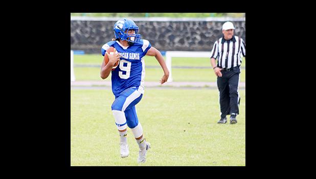 Samoana quarterback Anthony Feala, storming through mid-field as he checks for nearby defenders – in the second half of their JV game last Saturday morning. Feala led the Sharks in their 18 - 0 win against Nu’uuli, as their final game of the season.  [photo: TG]