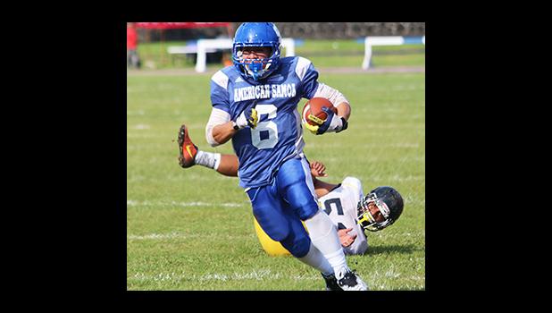 Louis Malala Jr., the strongest workhorse at Samoana’s backfield, looking towards the goal line after breaking a tackle from Uriah Te’o, in the opening half of their JV game last Saturday morning at the Veterans Memorial Stadium. Malala helped Samoana in their 36 - 20 victory.