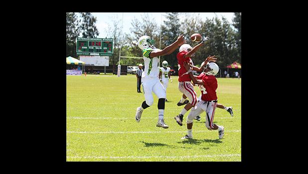 Two Vikings defenders collide while trying to cover Leone Lions wide receiver on this deep pass to the end zone, an attempt by the Lions in the second quarter of the JV match up last Saturday at the Veterans Memorial Stadium – Leone lost to the Vikings 28 - 14. [photo: TG]