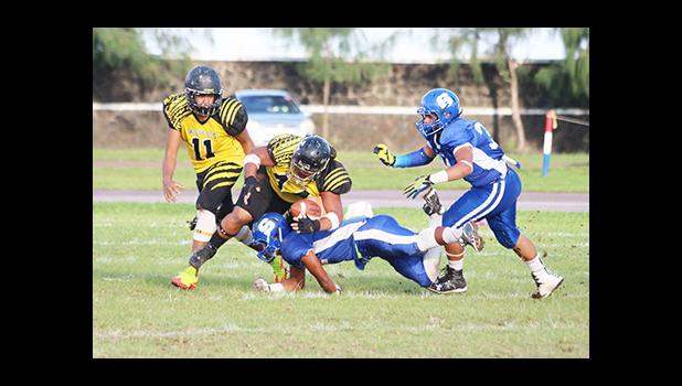 Fred Meredith of the Wildcats gets brought down by Samoana’s Fa’au Seumanutafa. The play caused a fumble in the opening quarter of their varsity game last Friday evening. Samoana beat the Wildcats 13 - 6, winning their first victory of the season.  [photo: TG]