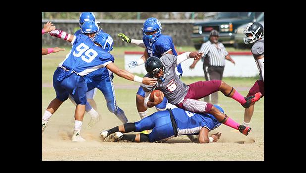 Pete Fa’avae of the Warriors taken down there by Samoana’s Cornelius Aiava, in the opening half of their varsity game last Saturday morning. The Warriors defeated the Sharks 28 - 12. [photo: TG]