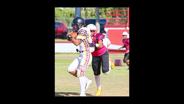 Niles Tuamoheloa trying to break away from a Viking just after a catch during the first quarter of their Varsity match last Saturday. Tuamoheloa scored the opening touchdown of their rivalry match – he helped the Warriors in their 26 - 16 victory. [photo: TG]