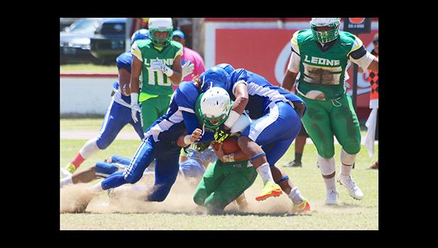 David Mikaele and Vimoto Mageo sandwich tackle Leone Lions running back Luteru Ah Loe, in the opening half of their varsity rivalry game last Saturday – Samoana won over the Lions 6 - 0. [photo: TG]