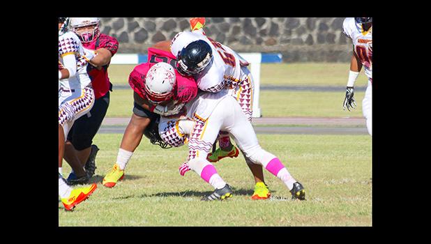 Two Warrior defenders taking down Faga’itua’s work horse T.I. Farani during the opening quarter of their Battle of the Toa’s varsity rival game last Saturday morning. Warriors are now No.1 in Varsity competition in ASHSAA Football League competition. [photo: TG]