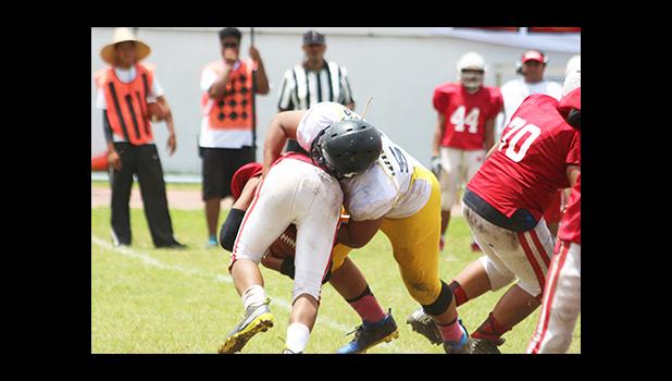 Heini Ta’ase getting hammered in the backfield for a loss by Uriah Te’o of Nu’uuli, as he didn’t fall for the option give this time – in the second quarter of the JV match last Saturday. Faga’itua won 28 - 8. [photo: TG]