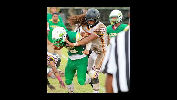 Leone’s new quarterback Ui’ese getting hammered by Penei Pavihi as Ui’ese finally gets acquainted with one of Tafuna’s finest, in the second half of their varsity game.  [photo: TG]
