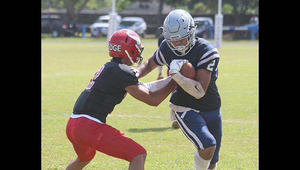 Samoana Sharks wide receiver Avery Seumanutafa trying to escape a tackle by Fitu Amata