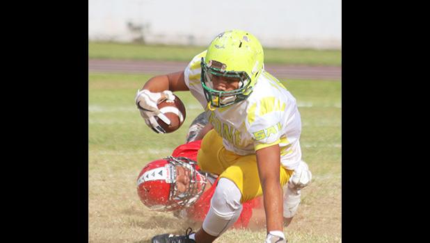 A Leone Lions running back is dragged down in the backfield by a Viking defender