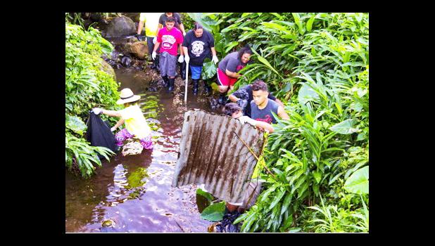 Youth volunteers remove scrap metal from the Vaitele stream 