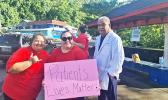 Nurses with sign as doctor looks on