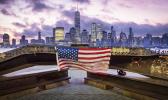 A U.S. flag hanging from a steel girder, damaged in the Sept. 11, 2001 attacks on the World Trade Center, blows in the breeze at a memorial in Jersey City, N.J., Sept. 11, 2019 as the sun rises behind One World Trade Center building and the re-developed area where the Twin Towers of World Trade Center once stood in New York City on the 18th anniversary of the attacks. (AP Photo/J. David Ake) A U.S. flag hanging from a steel girder, damaged in the Sept. 11, 2001