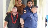 Deputy Commissioner Falana’ipupu Ta’ase Sagapolupele (left) and two other police officers escorting Police Officer Fa’auma Malo (right) from the DPS Central Station in Fagatogo, to an awaiting police unit, after he was arrested last Friday morning. Malo will make his initial appearance in the District Court today.  [photo: courtesy]