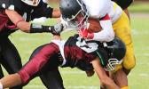 Wildcats Joseph Mauga gets hit hard by a Warrior defender during the opening half of their JV match up last Friday evening – the Wildcats collected their first win of the season over the Warriors 14 - 12. [photo: TG]