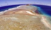 In this Nov. 5, 2015 file, aerial photo a small uninhabited island that has slipped beneath the water line only showing a small pile of rocks at low tide on Majuro Atoll in the Marshall Islands. To small island nations where the land juts just above the rising seas, the U.S. pulling out of the Paris global warming pact makes the future seem as fragile and built on hope as a sand castle. [AP file photo]