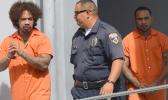 DPS police officer escorting prison escapees Joseph Iosefa Iakopo and Ryan Pite outside the District Court after their initial appearance yesterday morning.  [photo: AF]